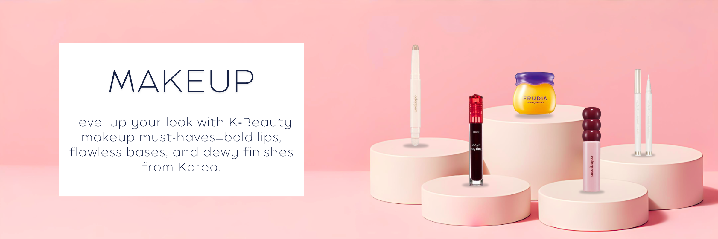K‑Beauty makeup collection featuring lipsticks, foundations, and glow-enhancing products on a soft pink display